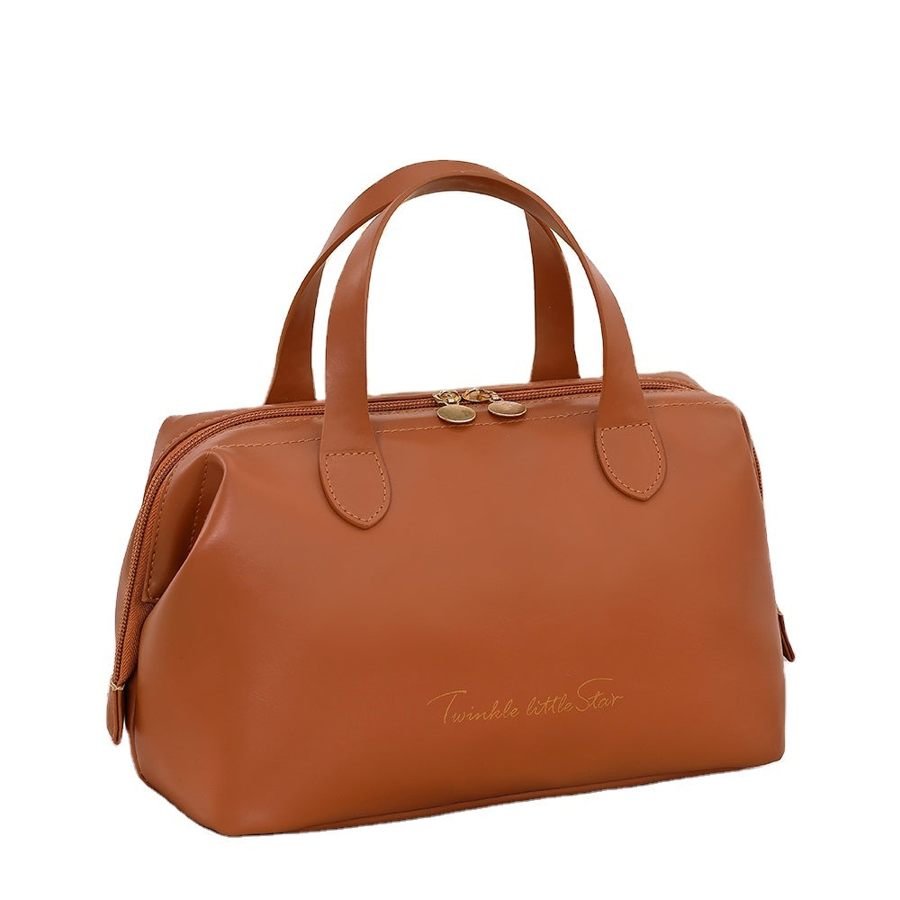 Brown beauty organizer bag with double handles, gold-tone clasp, and side zipper