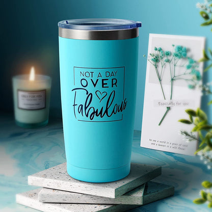 Teal tumbler candle with “Not a Day Over Fabulous,” plus gift card on spa set