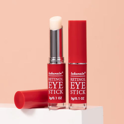 Red retinol eye stick with white balm cap, upright and lying