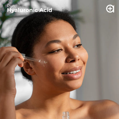 Woman applying clear serum drops to cheek with a dropper