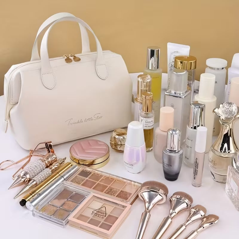 Cream beauty organizer bag with top zipper and handles, with makeup items around it
