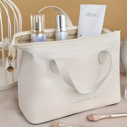 Cream beauty organizer bag with loop handles, top zipper, and toiletries inside