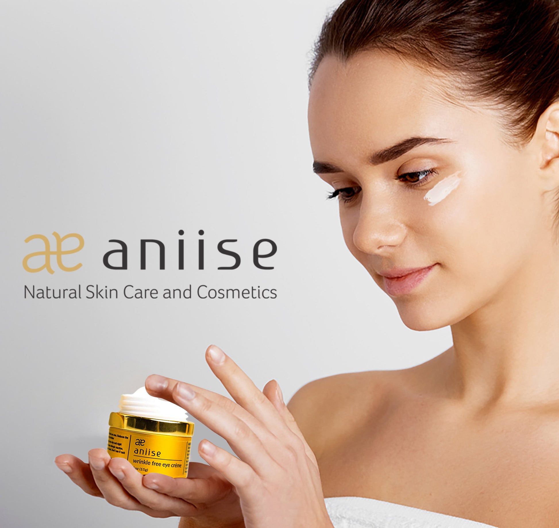 Wrinkle free eye crème jar with yellow body and gold lid, aniiise, held in hands