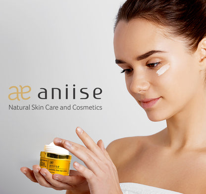 Wrinkle free eye crème jar with yellow body and gold lid, aniiise, held in hands